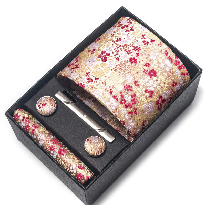 Floral tie set with tie, tie clip, and cufflinks in a black box on a white background