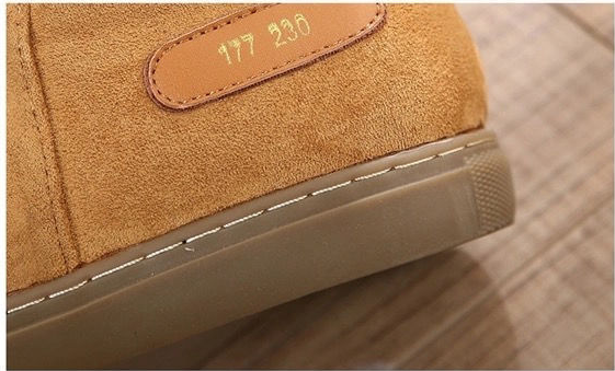 Close-up of a tan suede shoe with a tan leather patch embossed with the numbers '177 230' and a thick beige sole.