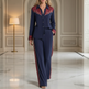 A woman models a matching navy blue two-piece lounge set with burgundy and cream western-style detailing on a polished marble floor in an elegant interior hallway.