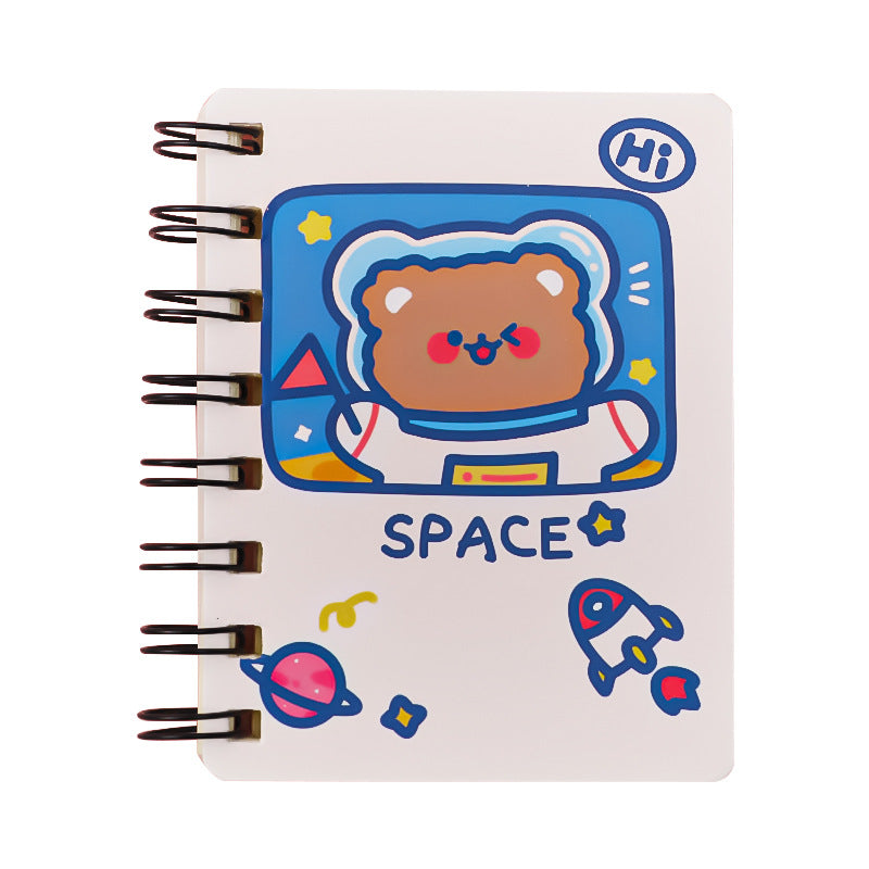 A spiral-bound notebook with a white cover featuring a cute cartoon bear astronaut under a blue 'SPACE' title, along with small space-themed illustrations.
