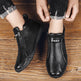 Black ankle boots with 'Daap' branding on a wooden floor.