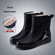 Black rain boots with white lining on a gray background