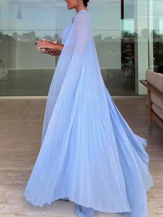 Woman wearing a light blue dress in an indoor setting with a cityscape view.