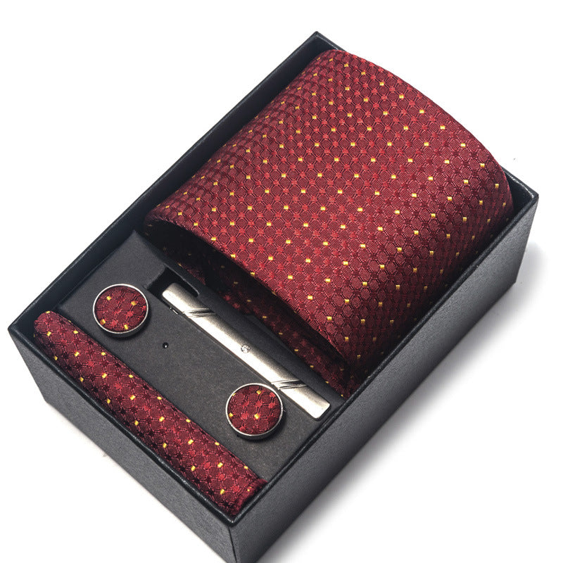 Maroon patterned tie, pocket square, and cufflinks set in a black box on a white background