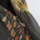 Close-up of a lightweight printed fabric accessory with a zipper, featuring a dark gray base and an abstract floral pattern in orange, pink, yellow, and green.