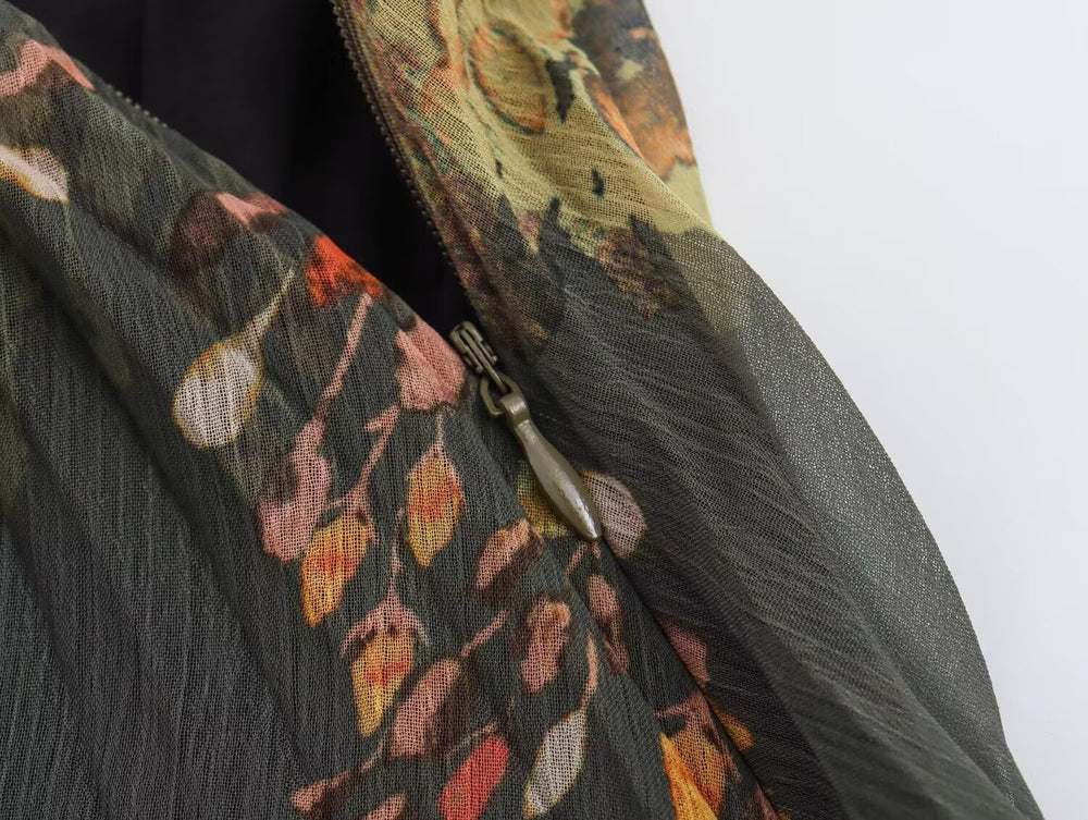 Close-up of a lightweight printed fabric accessory with a zipper, featuring a dark gray base and an abstract floral pattern in orange, pink, yellow, and green.