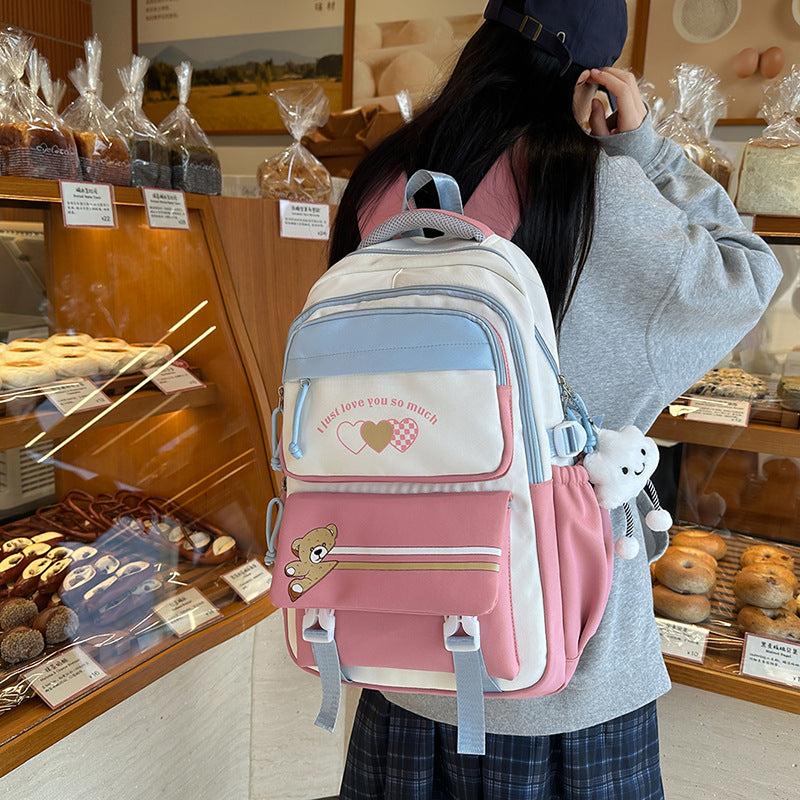 Person wearing a pink and white backpack with cartoon characters in a bakery.