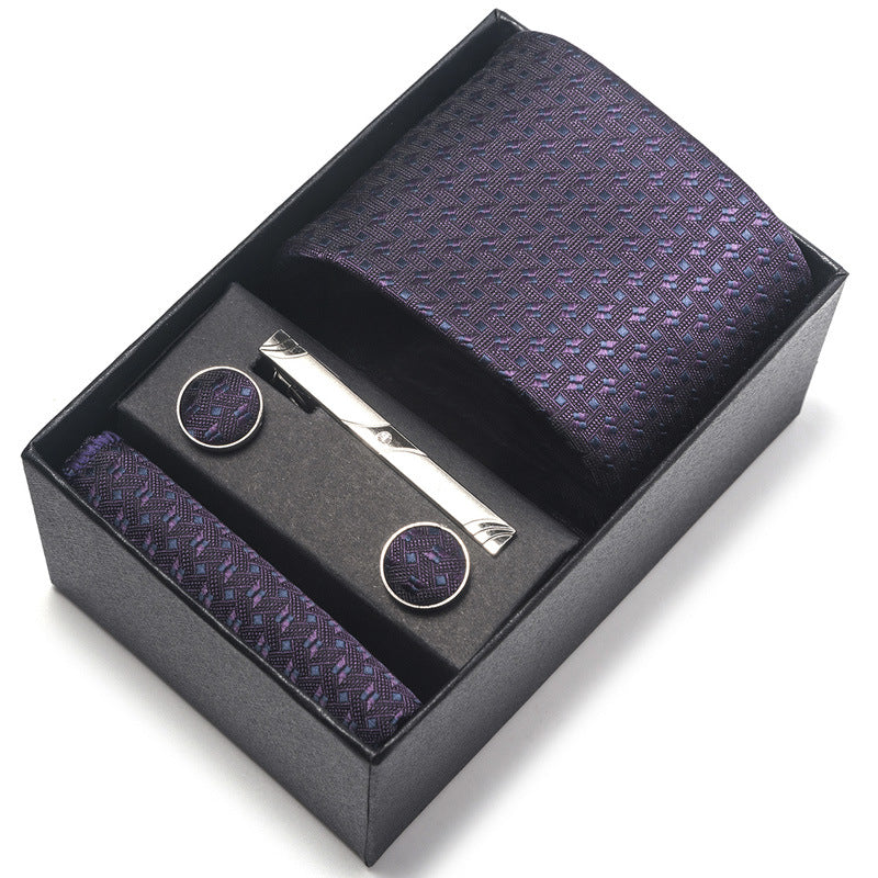Purple patterned tie set with tie clip and pocket square in a black box on a white background