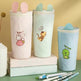 Three cute pencil cases with animal illustrations on a green surface.