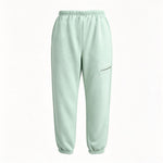 A pair of light mint green sweatpants with an elastic waistband and ankle cuffs, featuring a zippered pocket on the left thigh, shown against a plain white background.