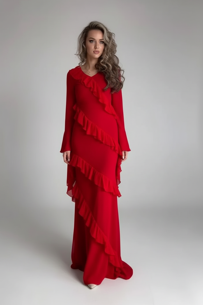 A woman modeling a long-sleeved red dress with cascading ruffle details, standing against a neutral light gray studio background.