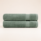 Two folded bath towels in a muted sage green color, stacked horizontally on a clean, solid, light beige background.