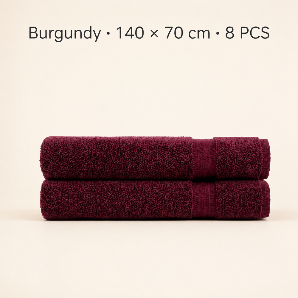 Two folded burgundy bath towels stacked horizontally on a light beige background, with text at the top reading 'Burgundy × 140 x 70 cm × 8 PCS'.