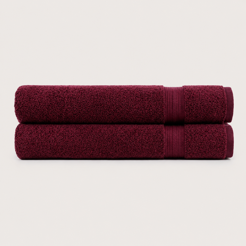 Two folded bath towels in a deep burgundy color, stacked horizontally on a light off-white background. Pure Cotton Bath Towel Set – Burgundy & Turquoise (74x33cm to 170x95cm)