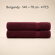Two folded burgundy towels stacked horizontally on a light beige background, with text at the top reading 'Burgundy × 140 x 70 cm · 4 PCS'.