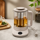 Multifunctional glass automatic tea maker brewing tea with stainless steel infuser in a kitchen setting